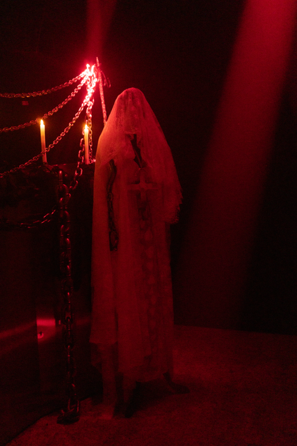 Stage decoration at CHERN Tokyo 2025 — doll in white dress with cross and chains